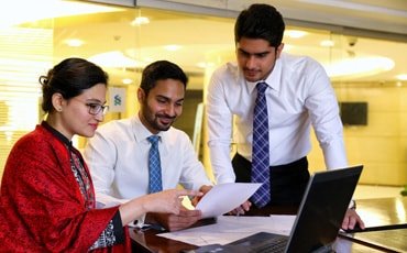 Three people in a meeting discussing responsible banking