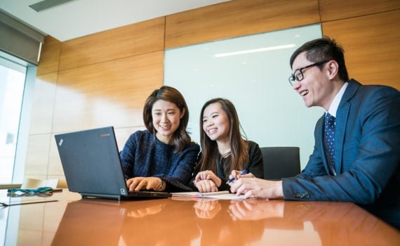 People looking at laptop, smiling