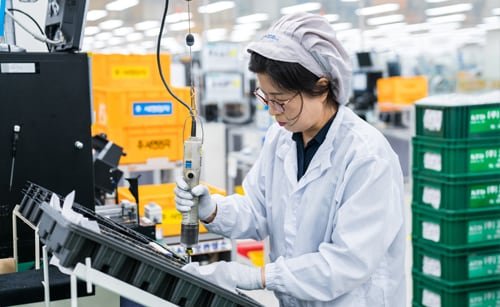 Female employee manufacturing car parts