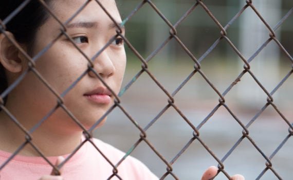 Girl behind wire fencing