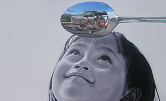 Girl looking at a reflection in a spoon